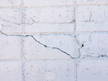 White brick wall texture with crack background for design. の写真素材