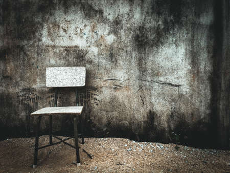 Small chair in front of dirty concrete wall with copy space