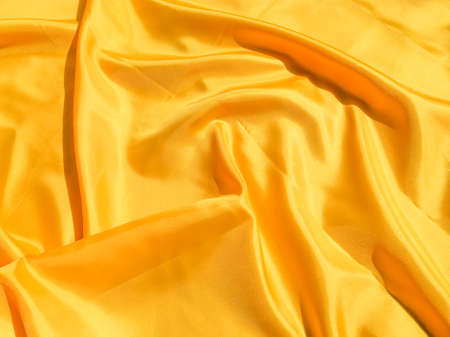 Beautiful yellow silk or satin texture background with copy space for design and artwork 