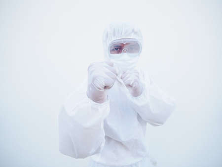 Doctor or scientist in PPE suite uniform standing with raised fists like boxer for fight with...