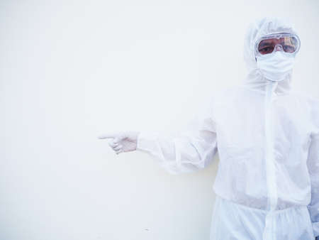 Asian male doctor or scientist in PPE suite uniform showing pointing fingers away at copy space...