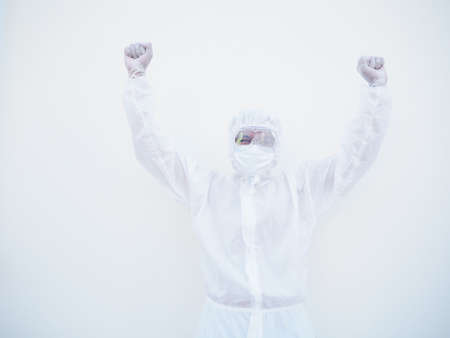 Successful emotional asian doctor or scientist in PPE suite uniform while looking ahead. clenches...