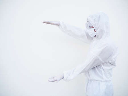 Asian doctor or scientist in PPE suite uniform showing holding something on hands for text or design on a white background. coronavirus or COVID-19 conceptの写真素材
