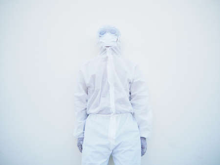 Asian male doctor or scientist in PPE suite uniform with wearing face mask protective. The mood is...