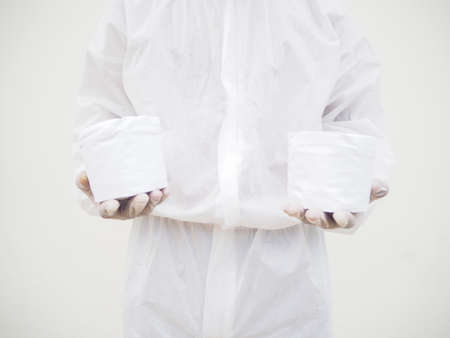 Asian male doctor or scientist in PPE suite uniform holding toilet paper. Lack of toilet paper in...