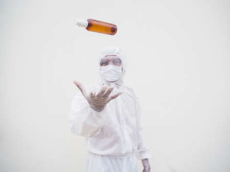 Portrait of doctor or scientist in PPE suite uniform holding plastic bottle with skin care product....