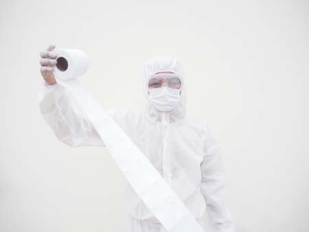 Asian male doctor or scientist in PPE suite uniform holding toilet paper. Lack of toilet paper in...