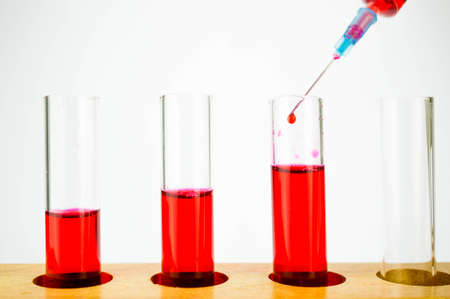 test tubes with red color chemical or blood and syringe drippingの写真素材