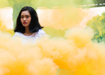 Asian Girl holding Yellow Smoke Flareの写真素材