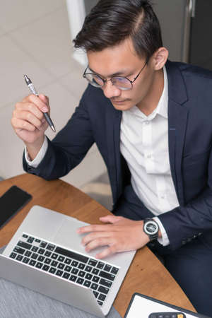 Asian malay man working at home with laptop