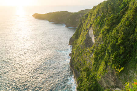 Beautiful sunset and amazing view of Kelingking beach or Manta bay on Nusa Penida island, Bali, Indonesiaの写真素材