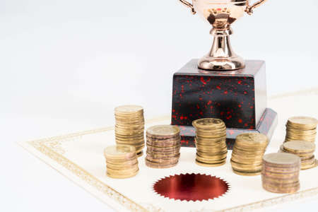 Trophy Cup and coins and blank certificate on white backgroundの写真素材