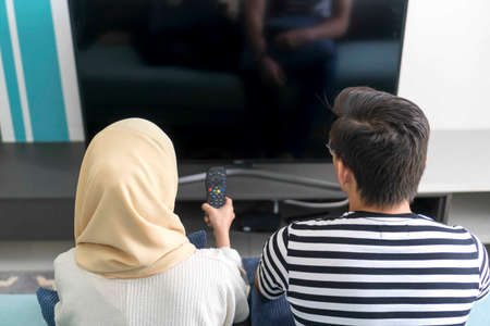 Young Malay Couple at the Sofa watching tv together