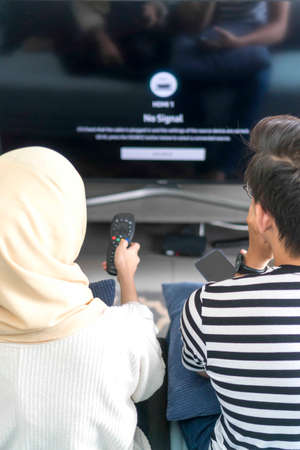 Young Malay Couple at the Sofa watching tv togetherの写真素材