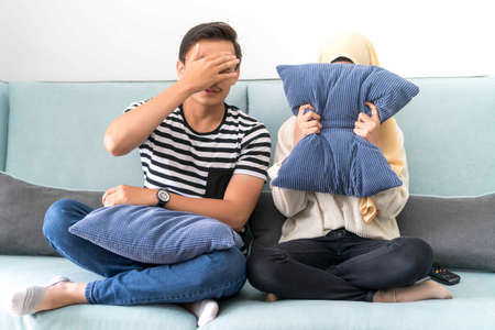 Young Malay Couple at the Sofa watching scary movie cover their eyesの写真素材