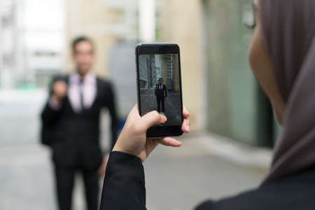 Hand holding mobile phone and taking photo