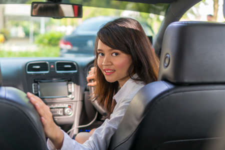 Cute Asian girl in the car smiling e-hailing concept