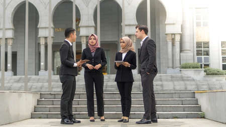 A group of young mixed Asian Executive at the wearing suit standing and talkingの写真素材