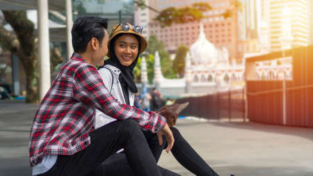 Travel Concept, Muslim Tourist Couple at Kuala Lumpur sitting on the street discussingの写真素材