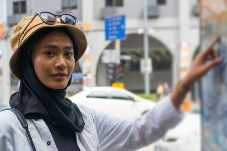 Travel Concept, Muslim Tourist Couple at Kuala Lumpur pointing at the street mapの写真素材