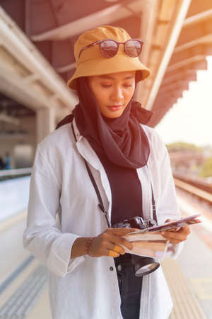 Travel Concept, Muslim Tourist Woman at Kuala Lumpur studying a map at the train stationの写真素材
