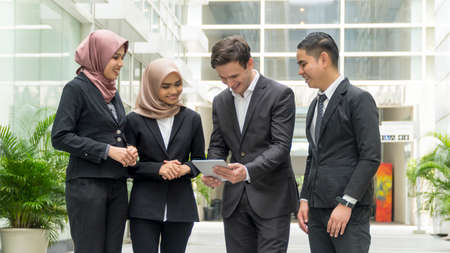 A group of young mixed Asian Executive at the wearing suit holding tablet computerの写真素材