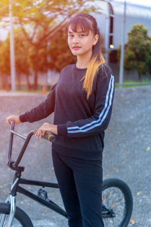Sporty lifestyle, young asian teen with a bicycle outdoorの写真素材