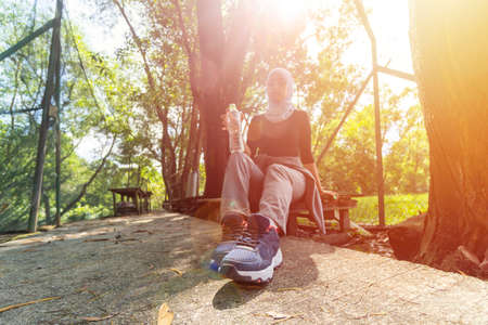 Healthy Lifestyle Concept, Malay Muslim lady wearing hijab outdoor resting and drink water
