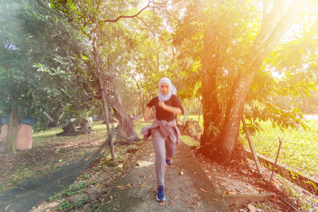 Healthy Lifestyle Concept, Malay Muslim lady wearing hijab outdoor running forwardの写真素材
