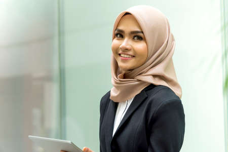 Business Lifestyle, Cute Malay Woman wearing hijab outdoor using tablet computerの写真素材