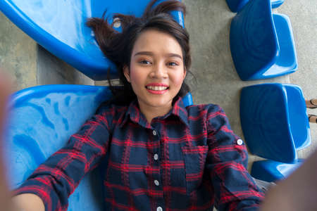 Student Lifestyle concept, cute asian girl selfie pov using smartphone at the benchの写真素材