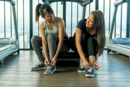 Healthy Concept, Cute Asian girl at the gym tying her shoes