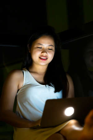 Lifestyle concept, Beautiful young Asian girl working with a laptop connecting to internet via computerの写真素材