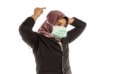 Business Lifestyle, Cute Malay Woman wearing hijab demonstrate how to use face maskの写真素材