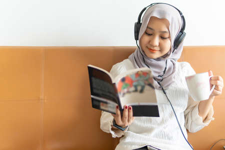 Lifestyle at home, cute malay woman at the sofa reading booksの写真素材