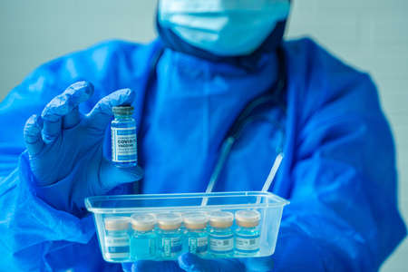 Women wearing PPE suit holding Coronavirus COVID-19 Vaccine Vials soft focusingの写真素材