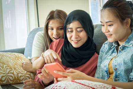 Urban lifestyle concept, Urban lifestyle concept, 3 asian lady at the sofa using smartphoneの写真素材