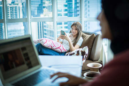 Online Dating Concept, Beautiful Asian girl at the sofa using smartphoneの写真素材