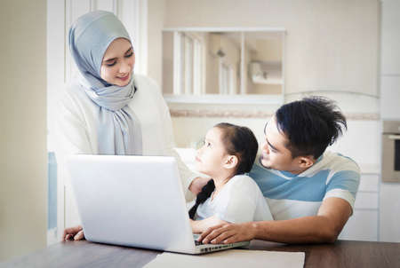 Family lifestyle concept, father or husband working from home while child is sitting on his lapの写真素材