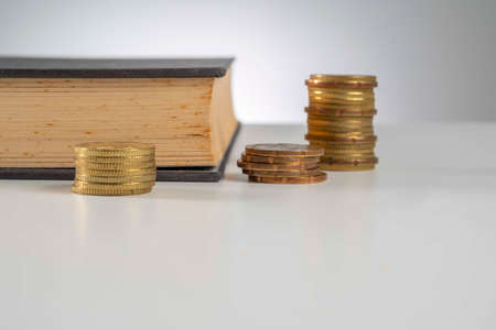 Finance Concept: Copy Space and arrangement of gold coin stack and old bookの写真素材