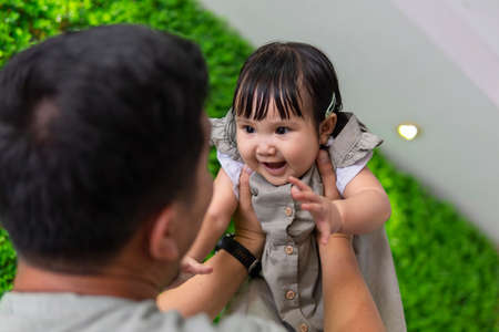 Family moment: Father holding holding baby up in the air
