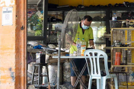 Shah Alam, Malaysia - Dec 24 2021: The aftermath of the flood at Taman Sri Muda Shah Alam, Selangor, Malaysia. Shop owner cleaningのeditorial素材