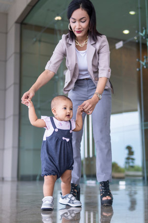 Family moment close-up of malay toddler learning to walkの写真素材