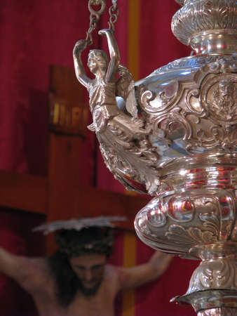 A silver lamp in the foreground with a Crucifix in the background in Floriana, Malta のeditorial素材