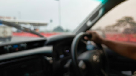 Defocused of man hand holding the steering wheel