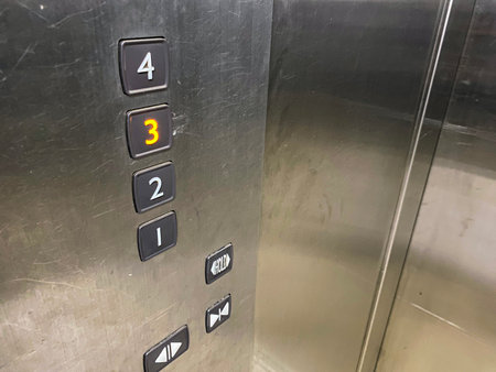 A close-up of an elevator control panel with the 3 button illuminated, indicating the current floor...
