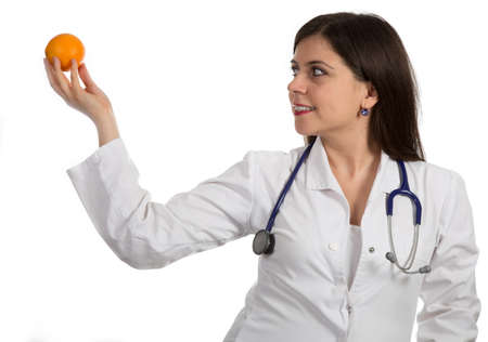 Closeup portrait of friendly, smiling confident female doctor holding orange, healthcare professional isolated on white background.の写真素材