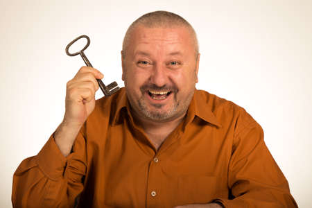 A man hold a key to success looking amazedの写真素材