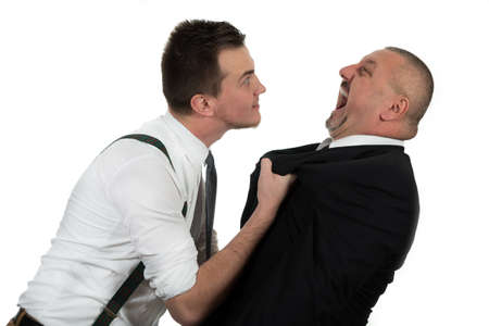 Businessman screaming and fighting at a young colleague isolated on whiteの写真素材