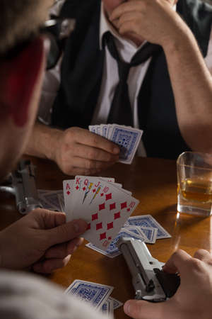 poker cards and handgun at table